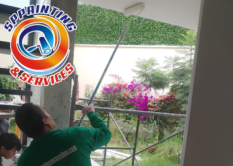 Pintores de casas aplicando recubrimiento interior