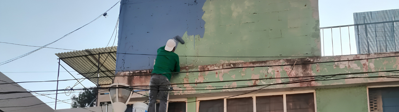 Pintores de casas realizando resane y pintura exterior